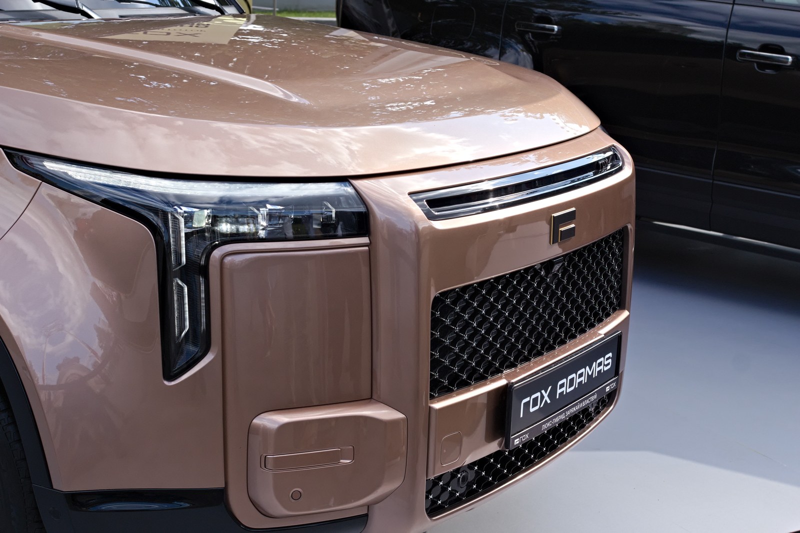 Bronze Rox Adamas large SUV shown from the front at a motor show